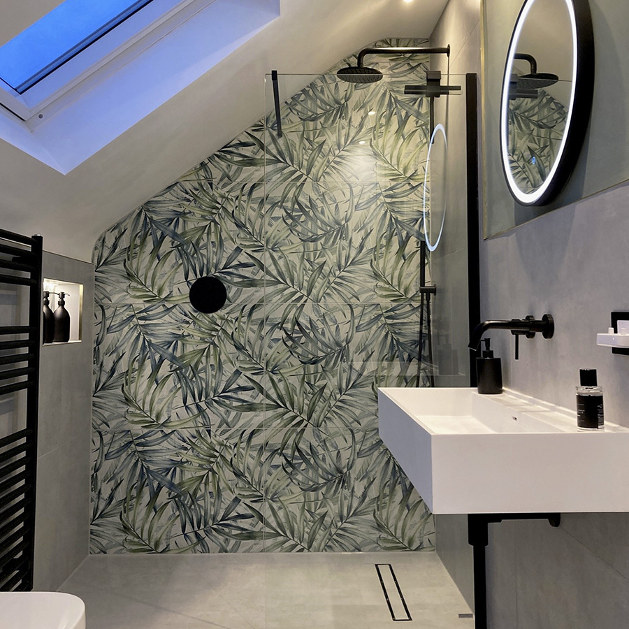 Botanical patterned feature wall tiles in a loft bathroom with sleek black accessories